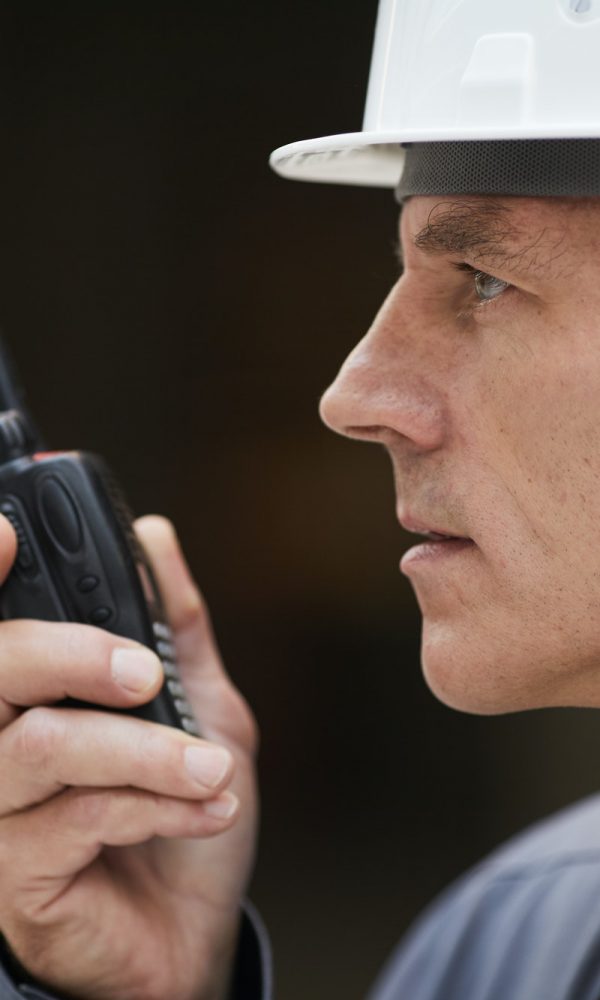 Construction Worker Speaking by Radio Side View